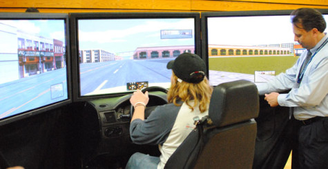 Madison College student Spencer White drives the virtual drunk driving simulator simulator as the operator increases the virtual level of alcohol.