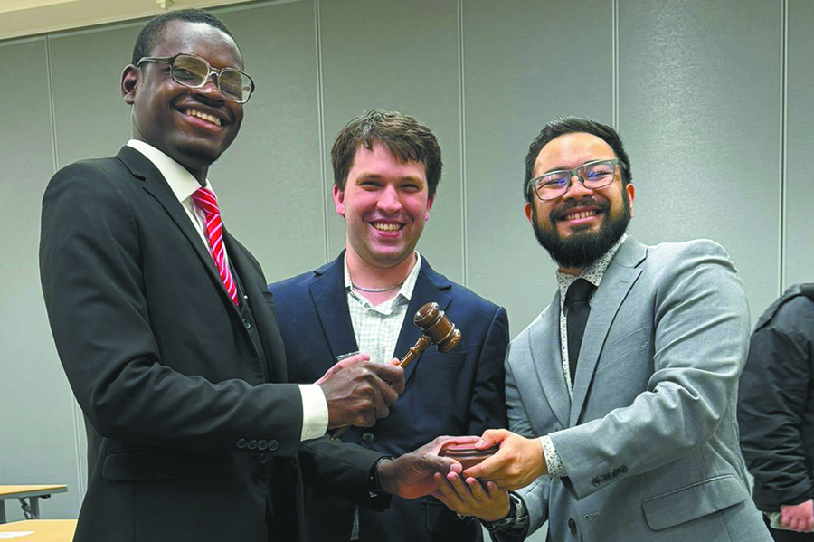 Former Student Senate President Jovahny Michaud, left, passes the gavel to new Student Senate President Kai Brito during a ceremony in May. Looking on is Mackenzie Carstens, the former Student Rep. to the District Board and current Student Senate member.