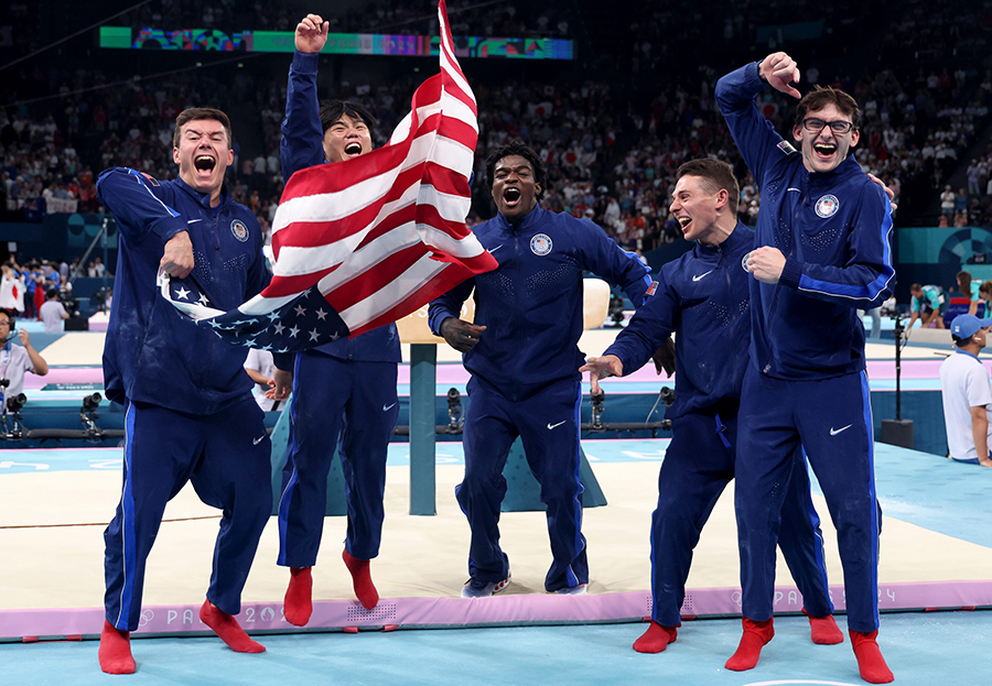 Members of the U.S. gymnastics team, Brody Malone, Asher Hong, Frederick Richard, Paul Juda and Stephen Nedoroscik  celebrate winning the bronze medal in the men's team final on July 29, 2024, in the Paris Olympics. (Brian Cassella / Chicago Tribune / TNS)