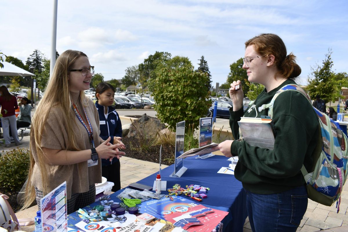 Scarlet Martino, a student program advisor who oversees voting and civic engagement across the college, speaks with a student about registering to vote.