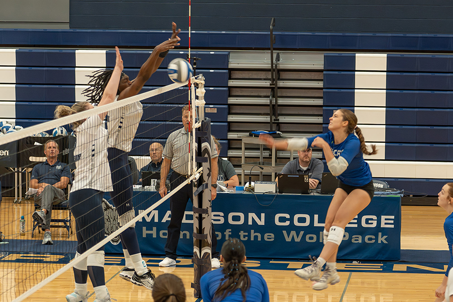 Courtney Gorum and Kate Howe jump in an attempt to block the incoming ball from a Bryant & Stratton College player.