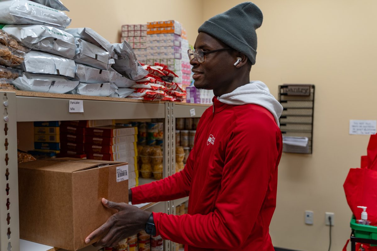 Jovhany Michaud puts food items away while working at the college's food pantry on Tuesday, Oct. 15, 2024.