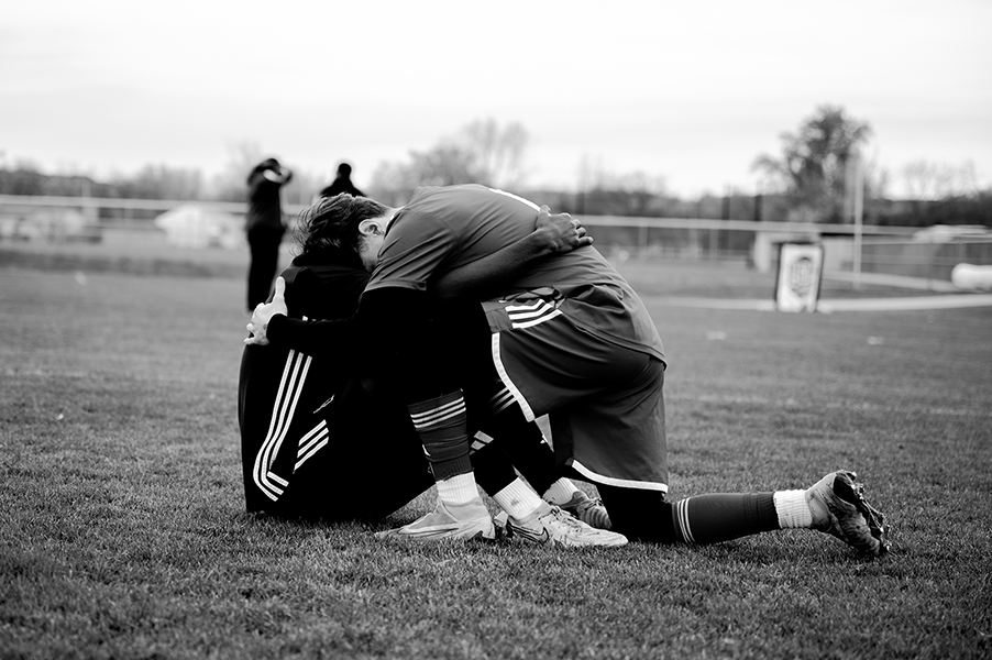 Two Madison College soccer players console each other on the field after a heart-wrenching overtime loss in the NJCAA Region 4 Tournament.