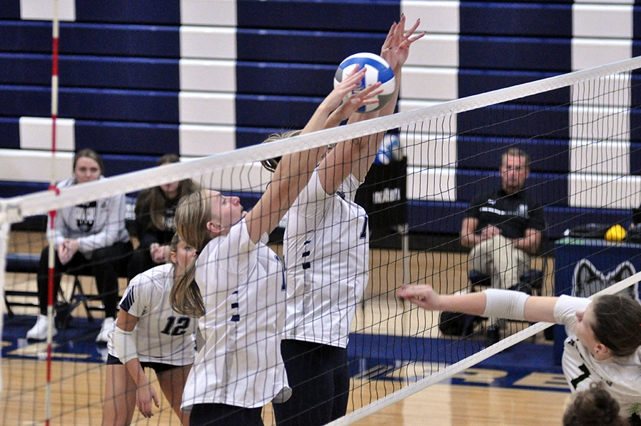 Madison College’s Emma Carpenter (left) and Amber Horn attempt to block a spike from a Bryant & Stratton College player during their NJCAA Region 4 Division II playoff game at Redsten Gymnasium on Nov. 6. The WolfPack won, 3-0.