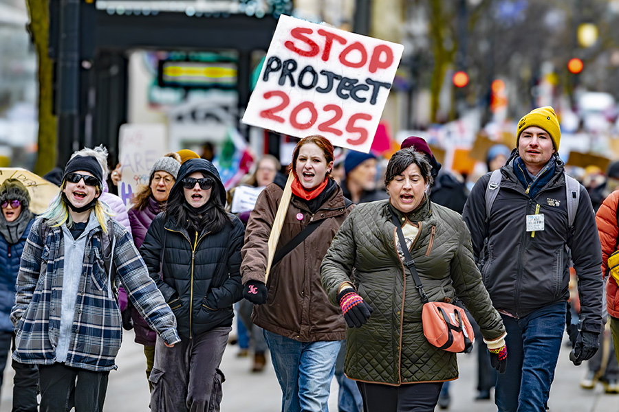 Protesters march down State Street in Madison on their way to the State Capitol on Feb. 25, protesting against Project 2025, the federal spending freeze and other actions of the administration.